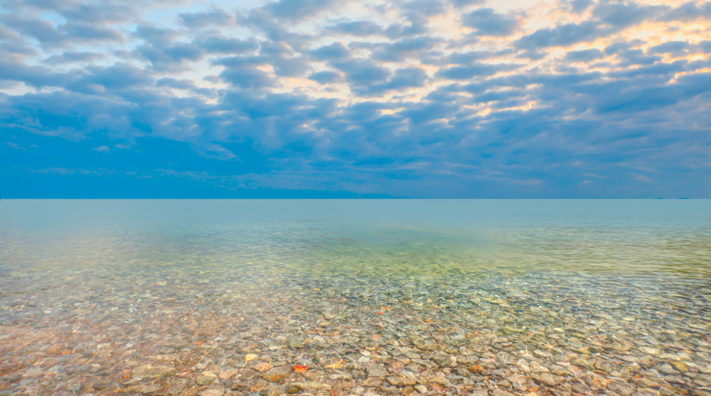 Pebble,Stones,On,The,Shore,With,Turqouise,Calm,Sea,At